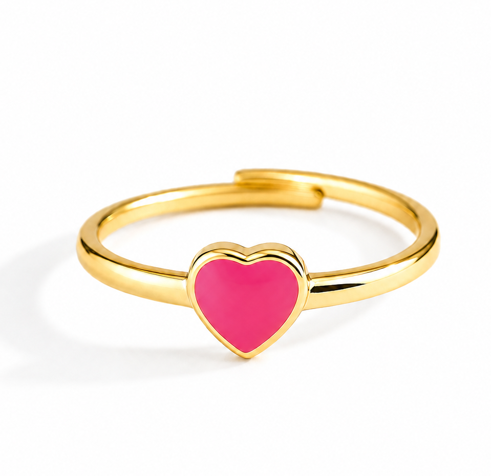 A gold-plated adjustable ring featuring a small, vibrant pink heart-shaped inlay at the center, shown on a clean white background.