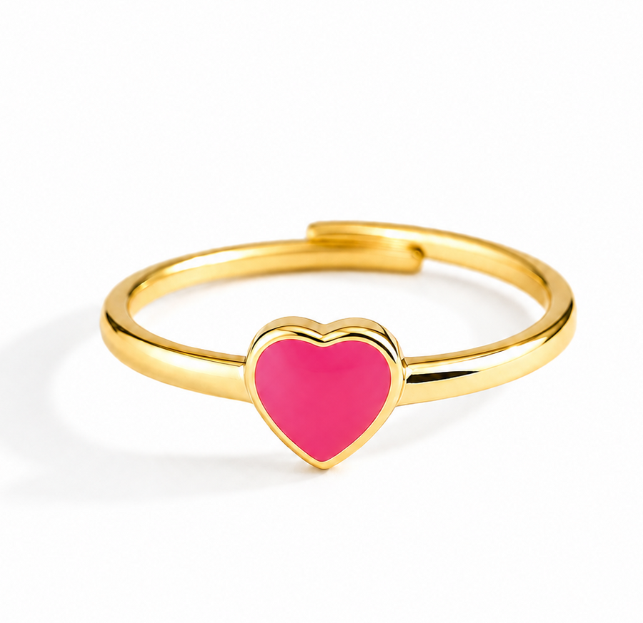 A gold-plated adjustable ring featuring a small, vibrant pink heart-shaped inlay at the center, shown on a clean white background.