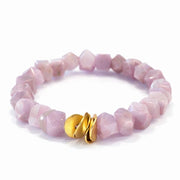 Pink beaded bracelet with a gold clasp on a white background
