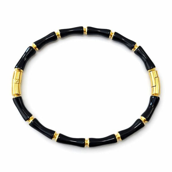 Black bracelet with gold accents on a white background