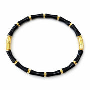 Black bracelet with gold accents on a white background