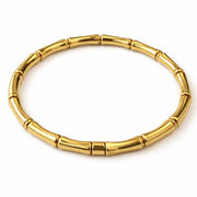 Gold bracelet with bamboo design on a white background