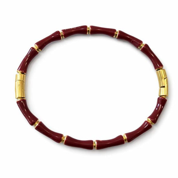 Red beaded bracelet with gold accents on a white background