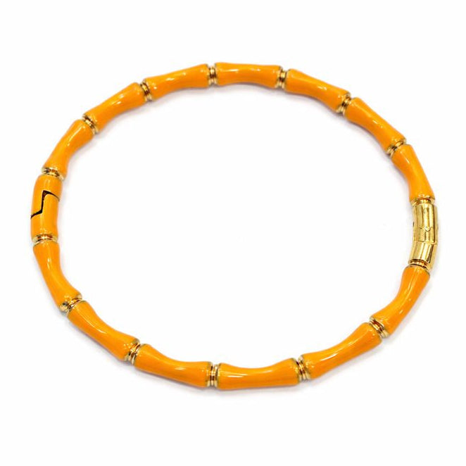 Orange bracelet with gold accents on a white background