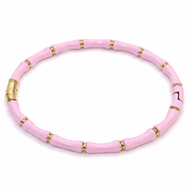 Pink beaded bracelet with gold accents on a white background