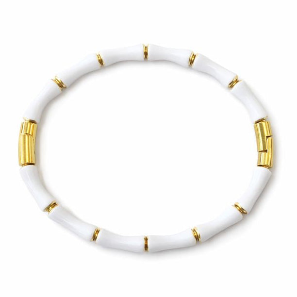 White bracelet with gold accents on a white background