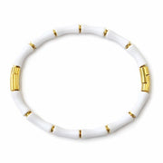 White bracelet with gold accents on a white background